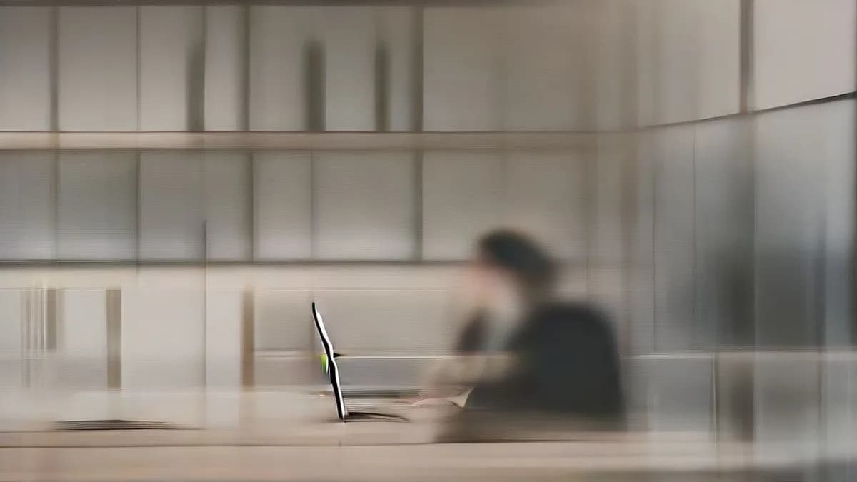 A professional working on a laptop in a modern office environment